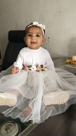 Portrait of cute baby girl sitting at home