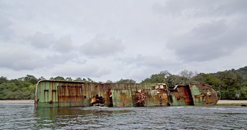 Old abandoned boat against sky