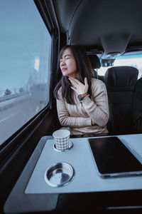 Portrait of young woman sitting in car