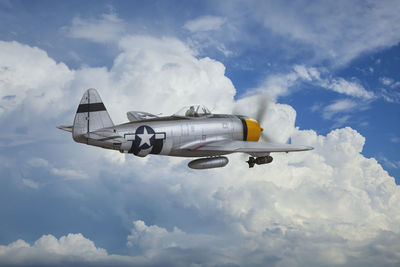 Low angle view of airplane flying against sky