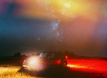 Cars on field against sky