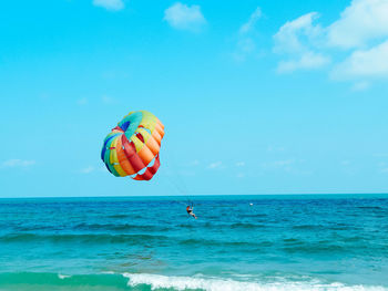 Kite flying over sea against sky