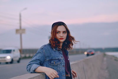 Portrait of beautiful young woman against sky during sunset