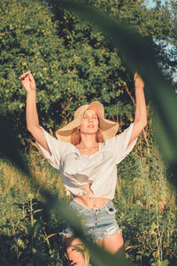 Young woman standing by plants