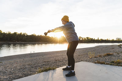Senior woman exercising with a kettlebell at the river