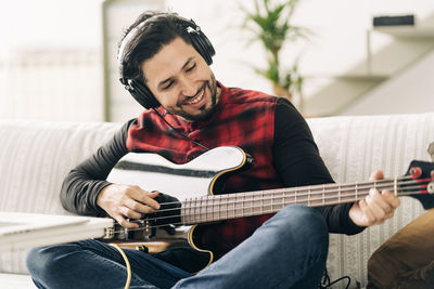 Young man playing guitar at home