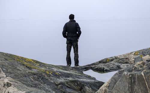 Rear view of man standing on rock