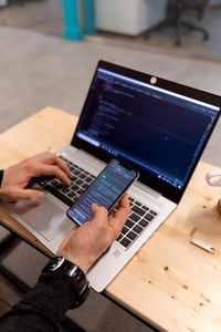 Cropped hands using laptop at table