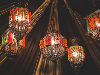 Low angle view of illuminated lanterns hanging on building