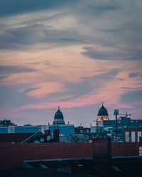 Buildings against cloudy sky at sunset