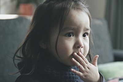 Close-up portrait of cute girl at home