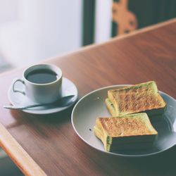 Close-up of black tea and sandwiches on table
