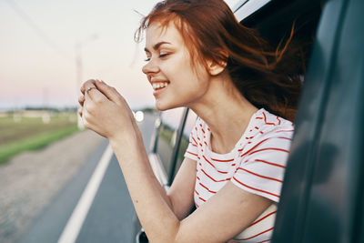 Young woman smiling while sitting in car