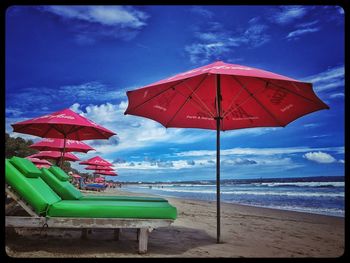 Multi colored umbrella on beach against sky