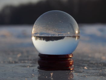 Close-up of crystal ball on beach