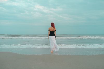 Rear view of woman standing on beach