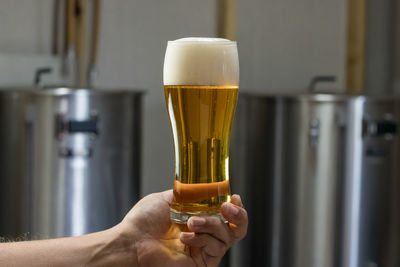 Close-up of hand holding beer glass