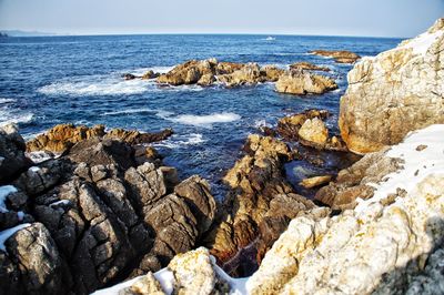 Rocks on beach against sky