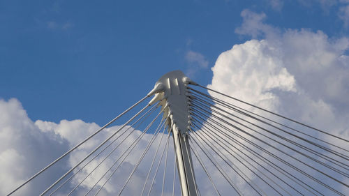 Low angle view of suspension bridge against cloudy sky