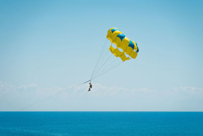 Parasailing over sea against sky