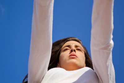 Low angle view of woman against blue sky