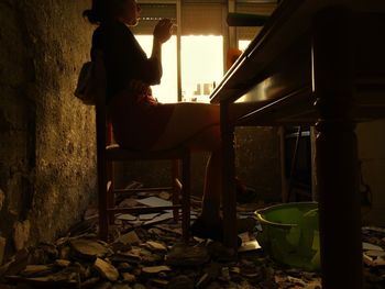 Woman sitting in abandoned house