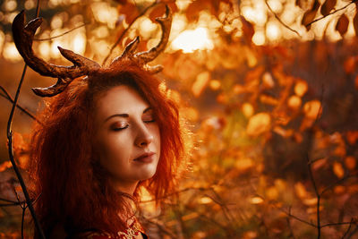 Portrait of young woman with autumn leaves