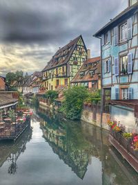 Canal amidst buildings against sky