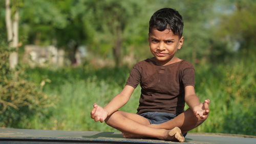 An indian boy doing yoga outdoors . healthy and peaceful lifestyle