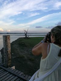 Rear view of woman on beach against sky