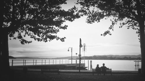 Silhouette of people on bench