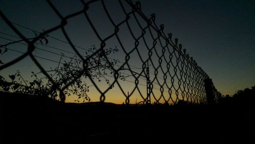 Silhouette of fence at sunset
