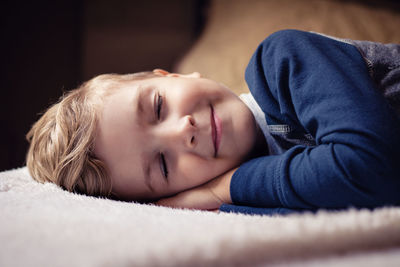 Close-up of boy sleeping on bed at home