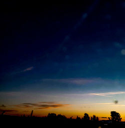 Silhouette trees against sky at night