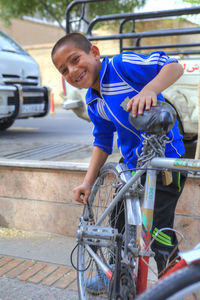 Portrait of smiling young man sitting on car