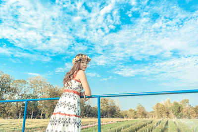 Woman standing on field against sky