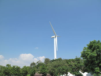 Low angle view of wind turbines against sky