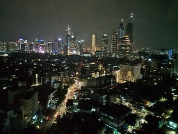 Illuminated cityscape against sky at night