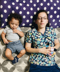 Mother and son lying on bed at home