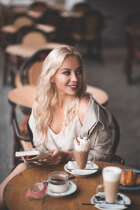 Young woman looking away while sitting at cafe