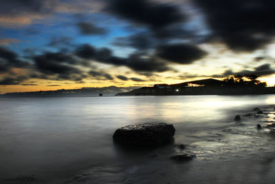 View of calm sea against cloudy sky during sunset