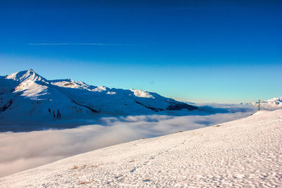 Scenic view of snowcapped mountains against blue sky