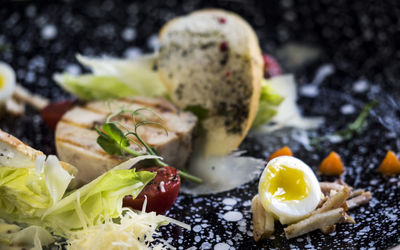 Close-up of chicken caesar salad with poached egg served in plate