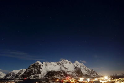 Scenic view of snowcapped mountains against sky at night