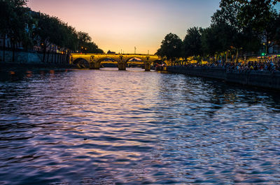 Bridge over river against sky during sunset