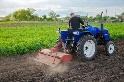 Farmer loosens and cultivates soil of field. milling soil, crushing before cutting rows. farming