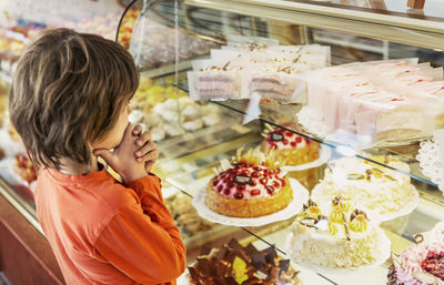 Boy looking at cakes