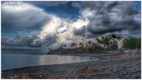 Scenic view of beach against cloudy sky