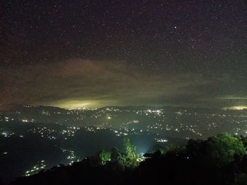 Illuminated cityscape against sky at night