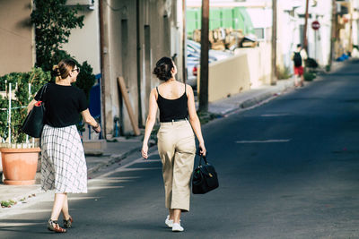 Rear view of women walking on road